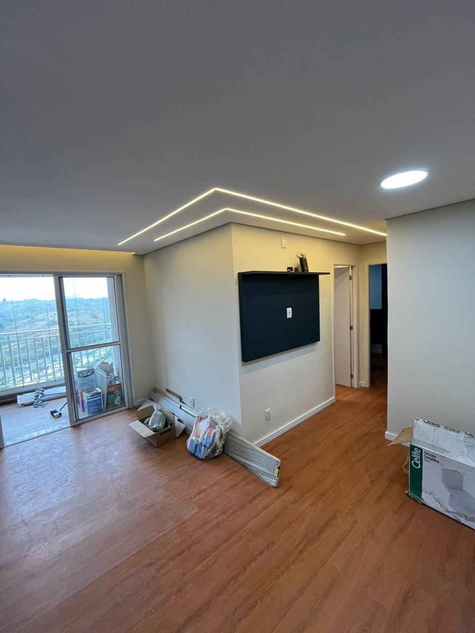 Sala de estar com painel de TV e iluminação embutida em LED